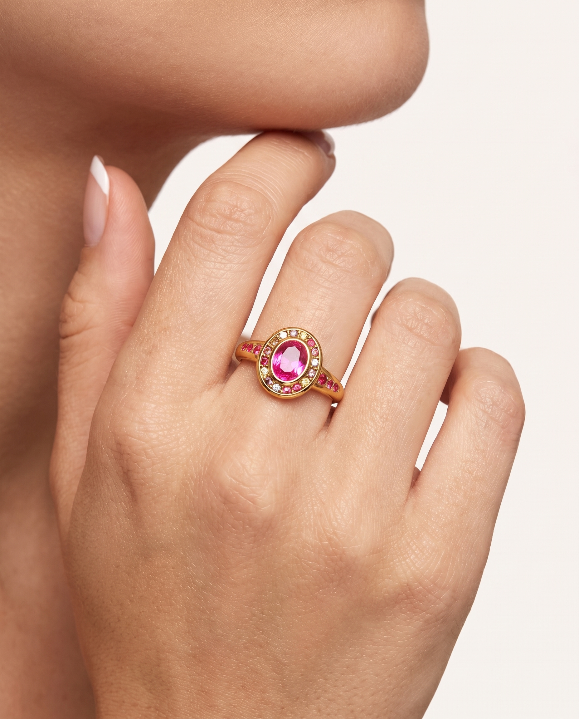 Colette gold halo ring worn on hand near face